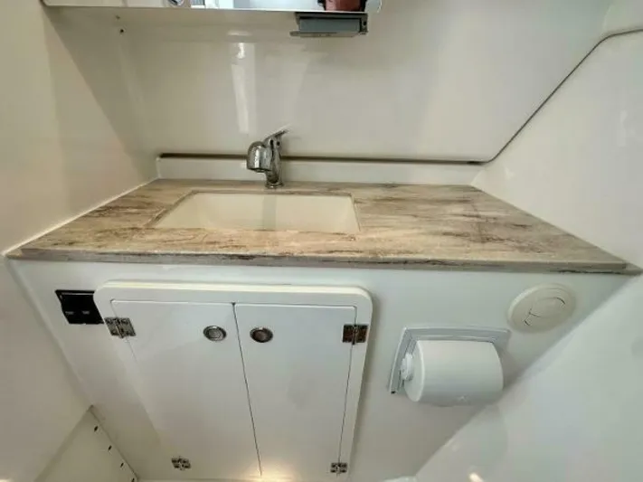  Yacht Photos Pics 2019 Pursuit DC 325 Dual Console bathroom with modern sink and storage cabinets.