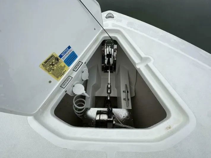  Yacht Photos Pics 2019 Pursuit DC 325 Dual Console anchor compartment with open hatch and visible anchor mechanism.