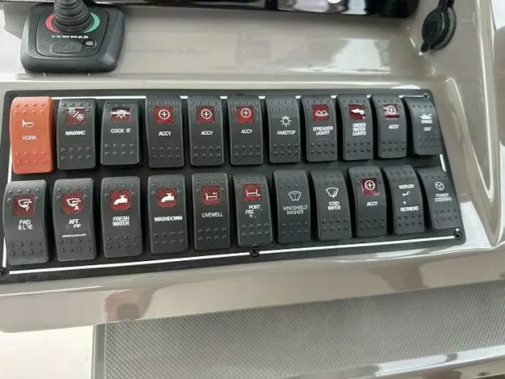  Yacht Photos Pics Control panel of a 2019 Pursuit DC 325 Dual Console boat with labeled switches.