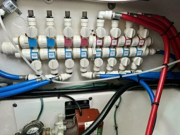  Yacht Photos Pics Plumbing system with labeled valves and colored pipes in a 2019 Pursuit DC 325 Dual Console boat.