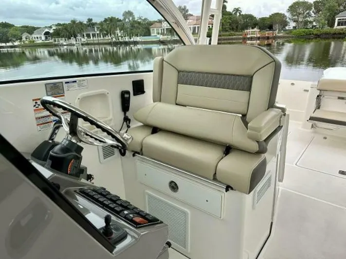  Yacht Photos Pics 2019 Pursuit DC 325 Dual Console helm with luxurious seating and scenic waterfront view.