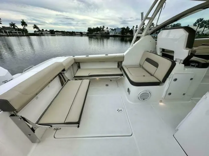  Yacht Photos Pics 2019 Pursuit DC 325 Dual Console boat interior with beige seating, overlooking calm waters.