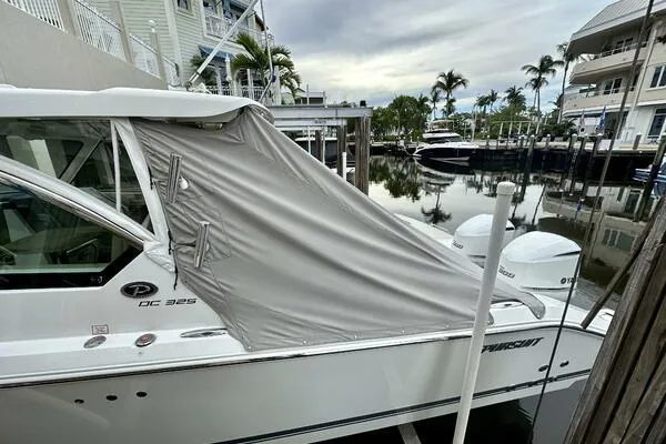  Yacht Photos Pics 2019 Pursuit DC 325 Dual Console boat docked with cover, surrounded by waterfront homes.