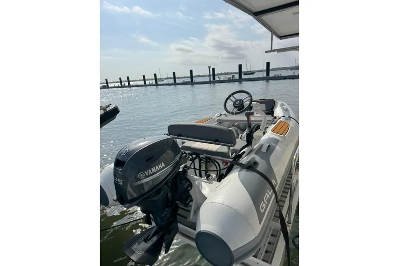 Exodus Yacht Photos Pics Inflatable boat with Yamaha motor on Lagoon 46, 2022 model, docked by the water.