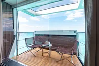 Luxurious Benetti Custom Built 2016 yacht balcony with ocean view, featuring modern chairs and table.