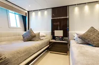 Luxurious twin bedroom on 2016 Benetti Custom Built yacht, featuring elegant decor and ambient lighting.