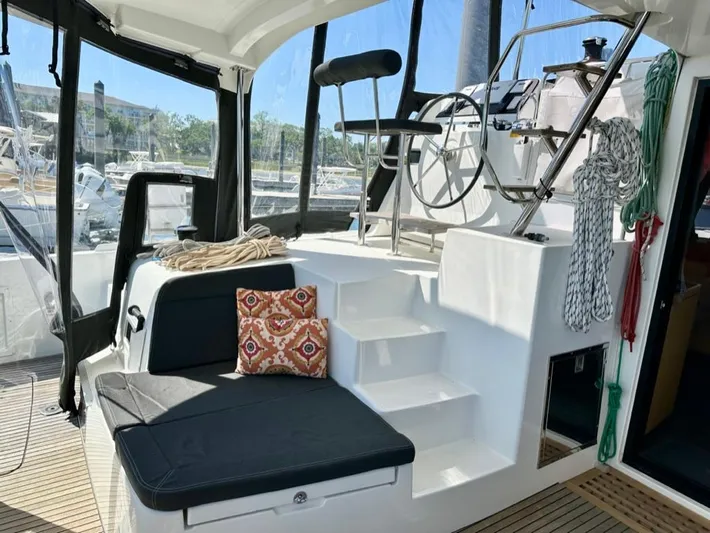 Never Say Never Yacht Photos Pics 2017 Lagoon 42 yacht cockpit with seating, steering wheel, and nautical ropes.