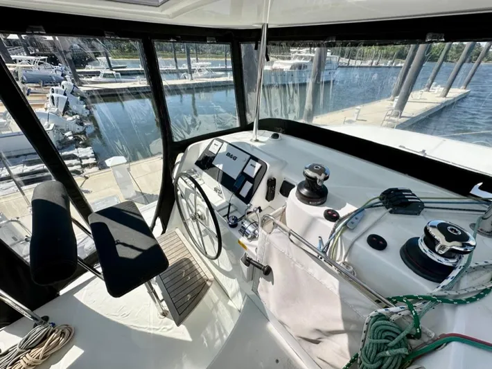 Never Say Never Yacht Photos Pics Helm of 2017 Lagoon 42 catamaran with marina view, featuring navigation equipment and winches.