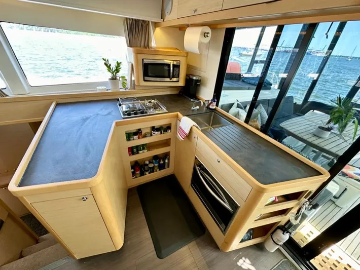 Never Say Never Yacht Photos Pics Modern kitchen in 2017 Lagoon 42 catamaran with ocean view, featuring stove, oven, and microwave.