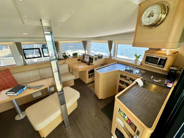 Never Say Never Yacht Photos Pics Interior of 2017 Lagoon 42 catamaran with modern kitchen and seating area, overlooking the sea.