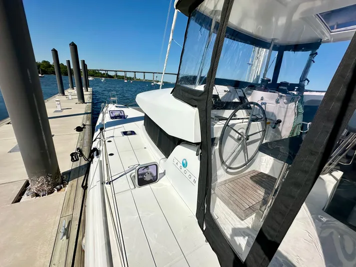 Never Say Never Yacht Photos Pics 2017 Lagoon 42 catamaran docked by a pier on a sunny day.