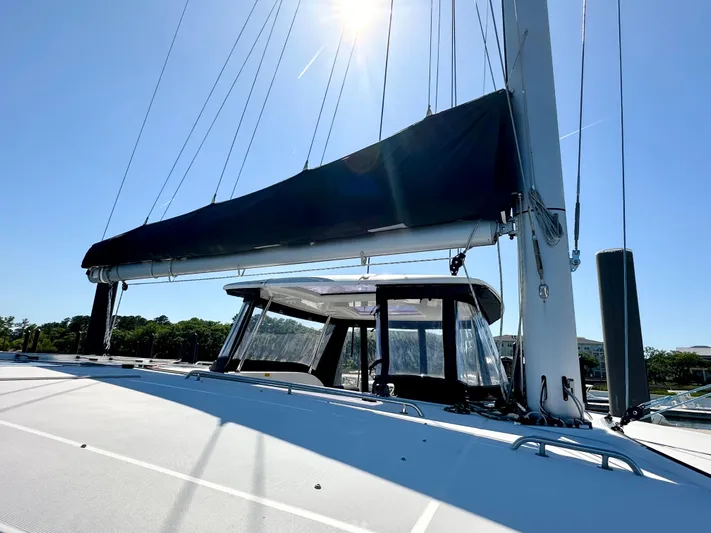 Never Say Never Yacht Photos Pics 2017 Lagoon 42 catamaran with sails, under bright sun, docked at marina.