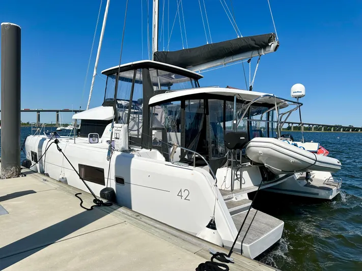 Never Say Never Yacht Photos Pics Lagoon 42 catamaran, 2017 model, docked at marina under clear blue sky.