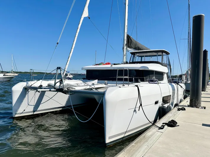 Never Say Never Yacht Photos Pics 2017 Lagoon 42 catamaran docked at marina under clear blue sky.