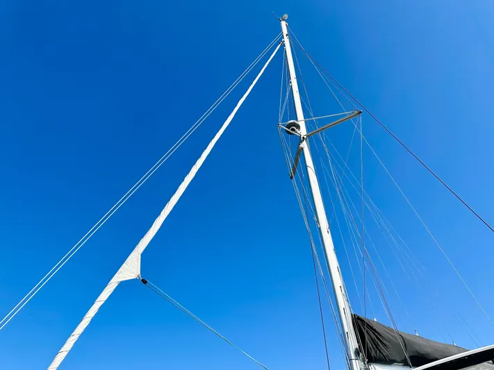 Never Say Never Yacht Photos Pics Mast of 2017 Lagoon 42 sailboat against clear blue sky.