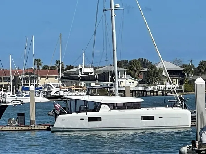 Never Say Never Yacht Photos Pics 2017 Lagoon 42 catamaran docked in a marina with clear blue skies.