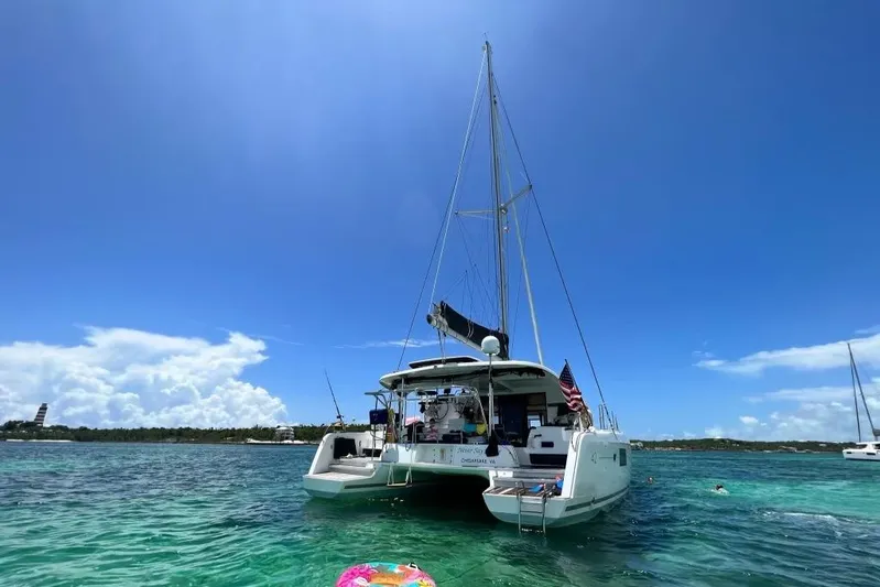Never Say Never Yacht Photos Pics 2017 Lagoon 42 catamaran anchored in clear blue waters under a sunny sky.