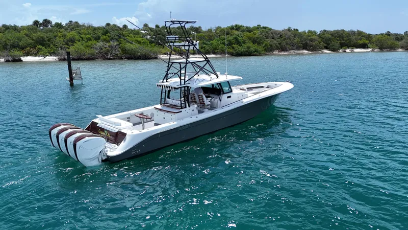  Yacht Photos Pics 2019 HCB 53 Sueños boat on clear blue water near a lush shoreline.
