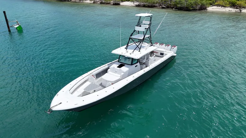  Yacht Photos Pics 2019 HCB 53 Sueños boat on clear turquoise water near a lush shoreline.