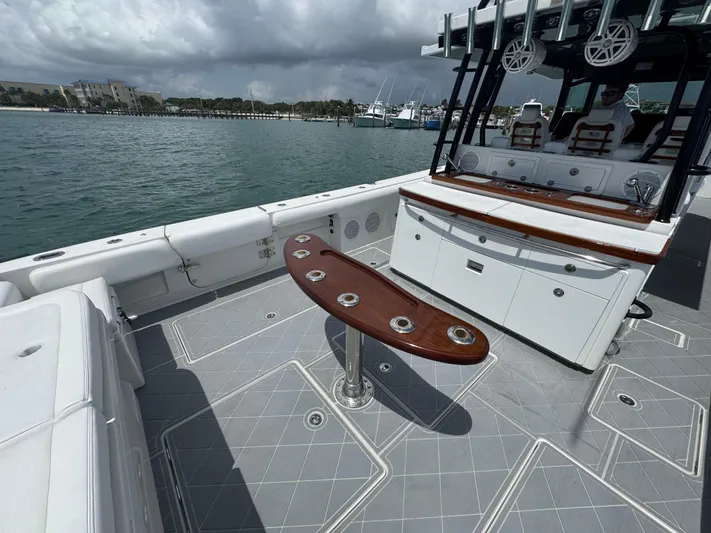  Yacht Photos Pics 2019 HCB 53 Sueños boat deck with seating and rod holders, docked by the water.