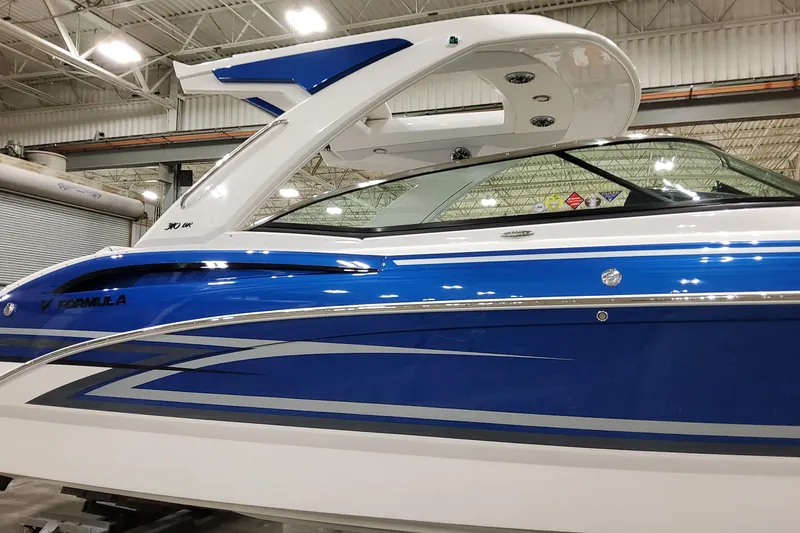  Yacht Photos Pics 2026 Formula 310 Bowrider I/O boat in showroom, featuring sleek blue and white design.