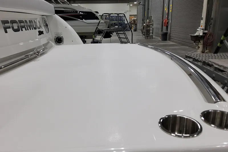  Yacht Photos Pics 2026 Formula 310 Bowrider I/O boat in showroom, showcasing sleek design and stainless steel features.