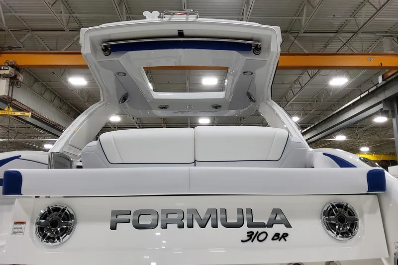  Yacht Photos Pics 2026 Formula 310 Bowrider I/O boat in a showroom, rear view with seating and speakers.