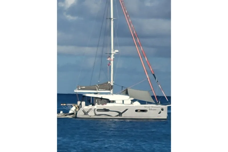  Yacht Photos Pics Sailing catamaran Excess 12, 2020 model, anchored on calm blue sea under cloudy sky.