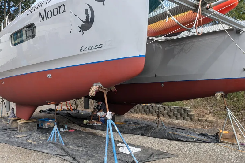  Yacht Photos Pics 2020 Excess 12 catamaran on land, undergoing maintenance with visible supports and tools.