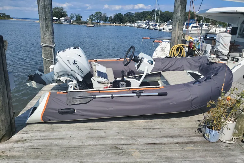  Yacht Photos Pics Inflatable boat with Tohatsu motor docked, Excess 12 model, 2020, at a marina.