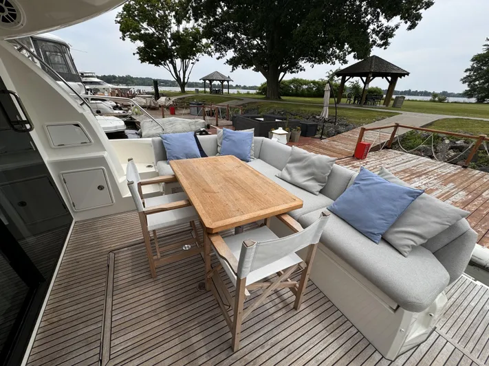  Yacht Photos Pics Luxurious 2020 Prestige 460S yacht deck with seating, table, and scenic waterfront view.