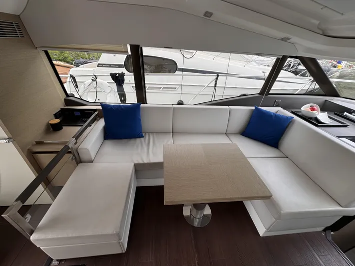  Yacht Photos Pics Luxurious interior of 2020 Prestige 460S yacht with white seating and blue cushions.