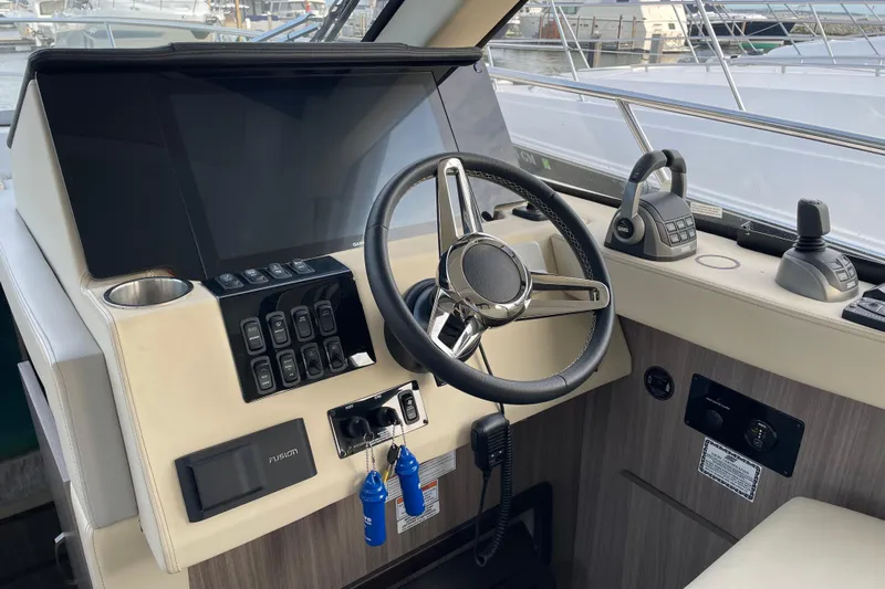 It's About Time Yacht Photos Pics 2022 Regal 38 Grande Coupe helm with steering wheel, controls, and navigation system.