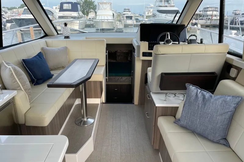 It's About Time Yacht Photos Pics Luxurious interior of 2022 Regal 38 Grande Coupe yacht with plush seating and modern helm.
