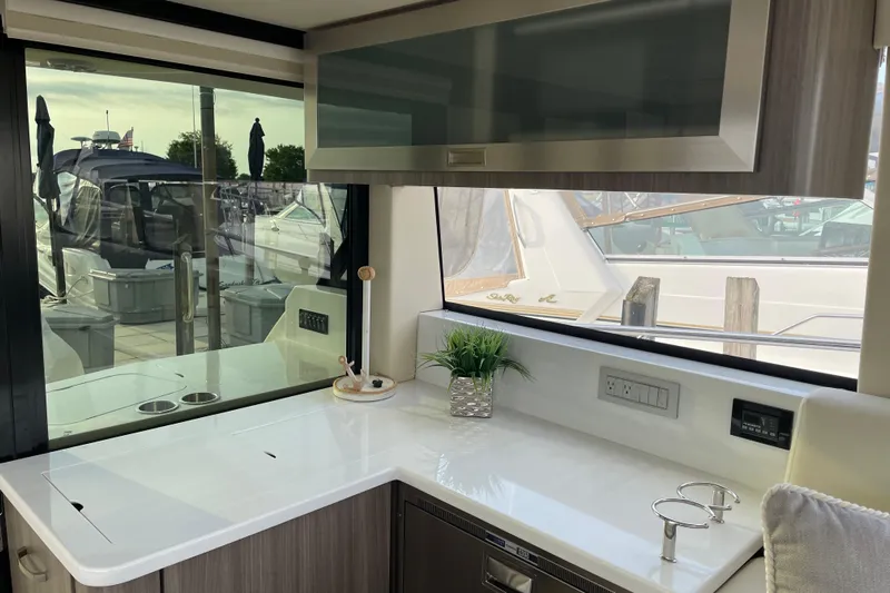 It's About Time Yacht Photos Pics Interior of 2022 Regal 38 Grande Coupe yacht with sleek kitchen counter and window view.