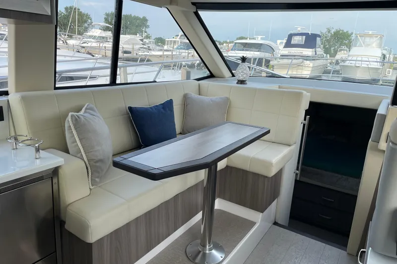 It's About Time Yacht Photos Pics Interior of 2022 Regal 38 Grande Coupe yacht with elegant seating and table.