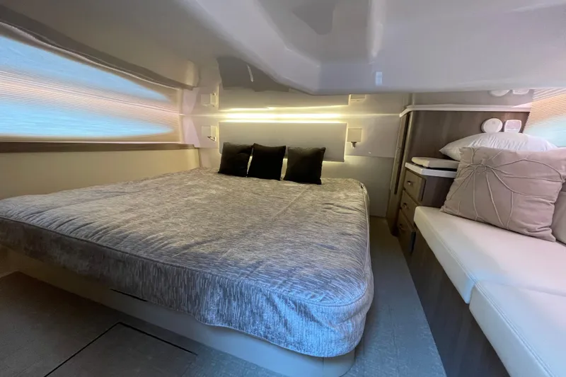 It's About Time Yacht Photos Pics Luxurious bedroom interior of 2022 Regal 38 Grande Coupe yacht, featuring elegant bedding and ambient lighting.