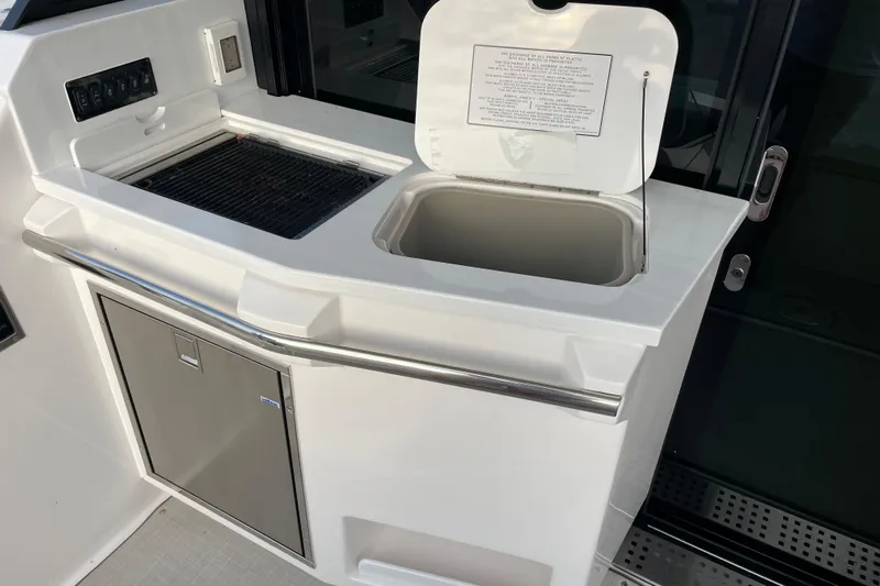 It's About Time Yacht Photos Pics Outdoor kitchen area on 2022 Regal 38 Grande Coupe yacht, featuring grill and sink.