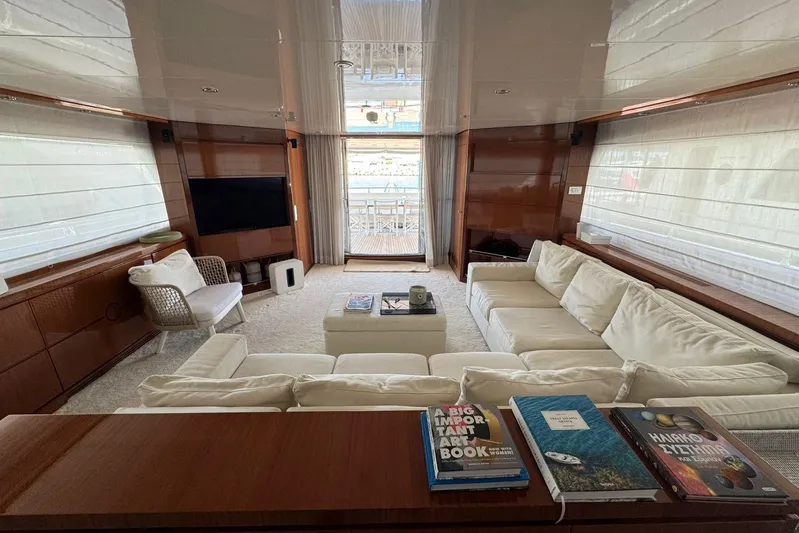  Yacht Photos Pics Luxurious Sanlorenzo SL88 yacht interior with white sofas, books, and a large window view.