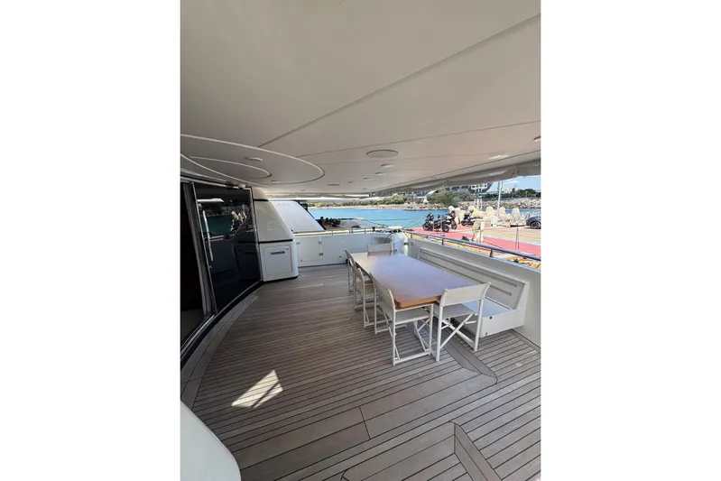  Yacht Photos Pics Spacious deck of 2003 Sanlorenzo SL88 yacht with wooden flooring and outdoor seating.