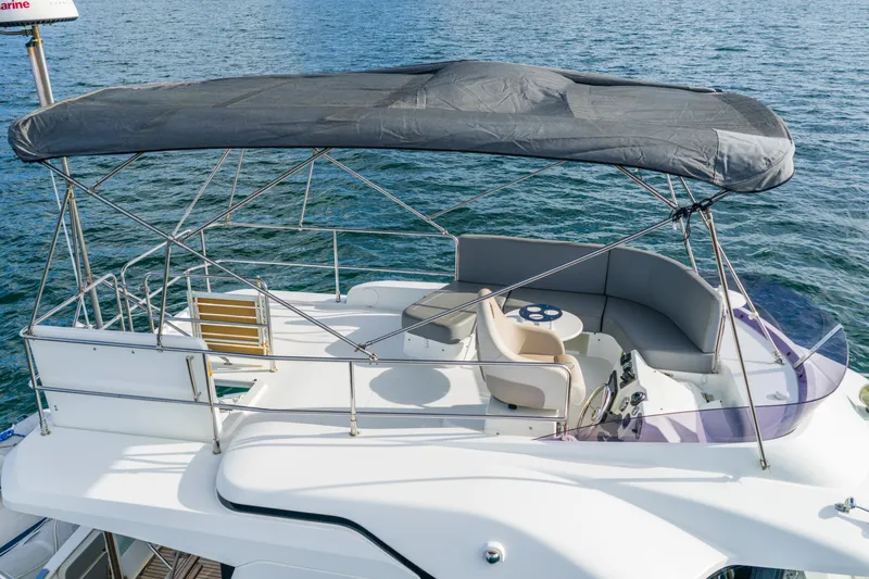  Yacht Photos Pics 2017 Beneteau Swift Trawler 30 flybridge with seating, canopy, and steering wheel on calm water.