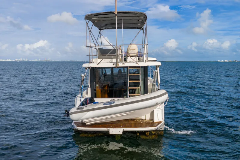  Yacht Photos Pics 2017 Beneteau Swift Trawler 30 on open water, rear view with inflatable boat.
