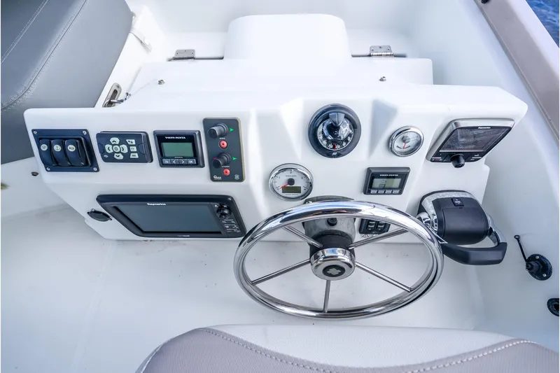  Yacht Photos Pics Control panel of 2017 Beneteau Swift Trawler 30 with steering wheel and navigation instruments.