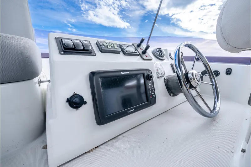  Yacht Photos Pics 2017 Beneteau Swift Trawler 30 helm with navigation controls and steering wheel.