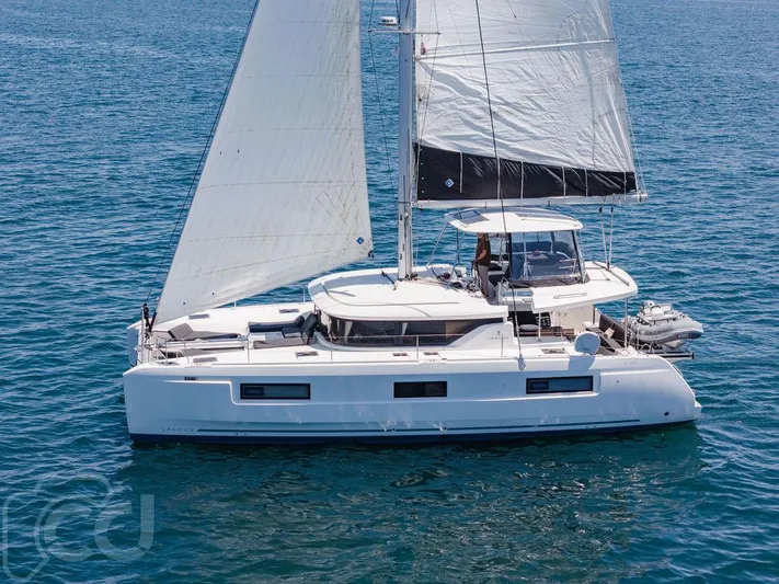 Flying B Yacht Photos Pics 2021 Lagoon 46 catamaran sailing on open water, showcasing sleek design and spacious deck.