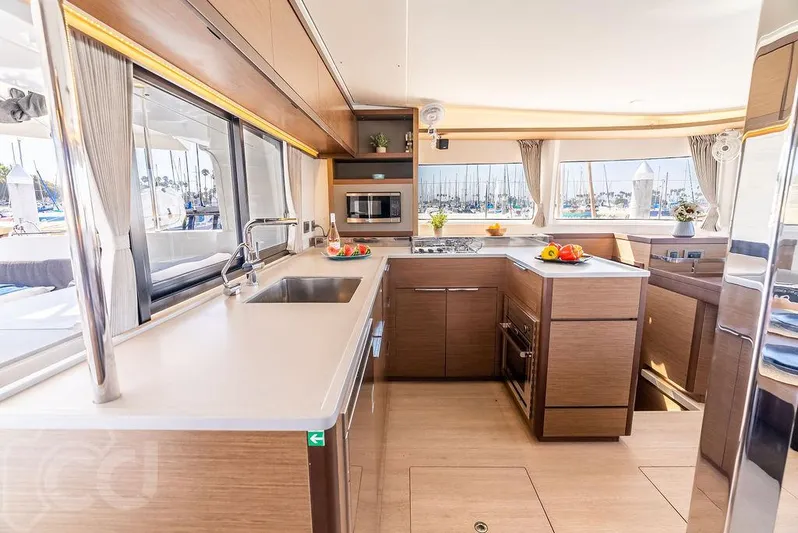 Flying B Yacht Photos Pics Modern kitchen interior of 2021 Lagoon 46 catamaran with sleek countertops and ample natural light.