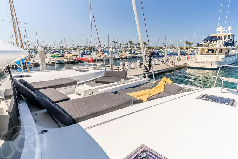 Flying B Yacht Photos Pics 2021 Lagoon 46 catamaran docked in a sunny marina with luxurious seating.