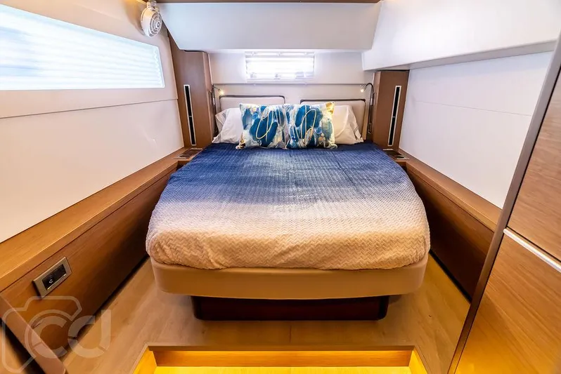 Flying B Yacht Photos Pics Luxurious bedroom interior of 2021 Lagoon 46 yacht with modern design and cozy bedding.