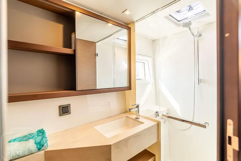 Flying B Yacht Photos Pics Modern bathroom in 2021 Lagoon 46 yacht with sleek sink, shower, and storage shelves.