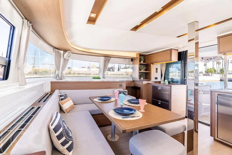 Flying B Yacht Photos Pics Luxurious interior of 2021 Lagoon 46 catamaran with elegant dining area and modern kitchen.